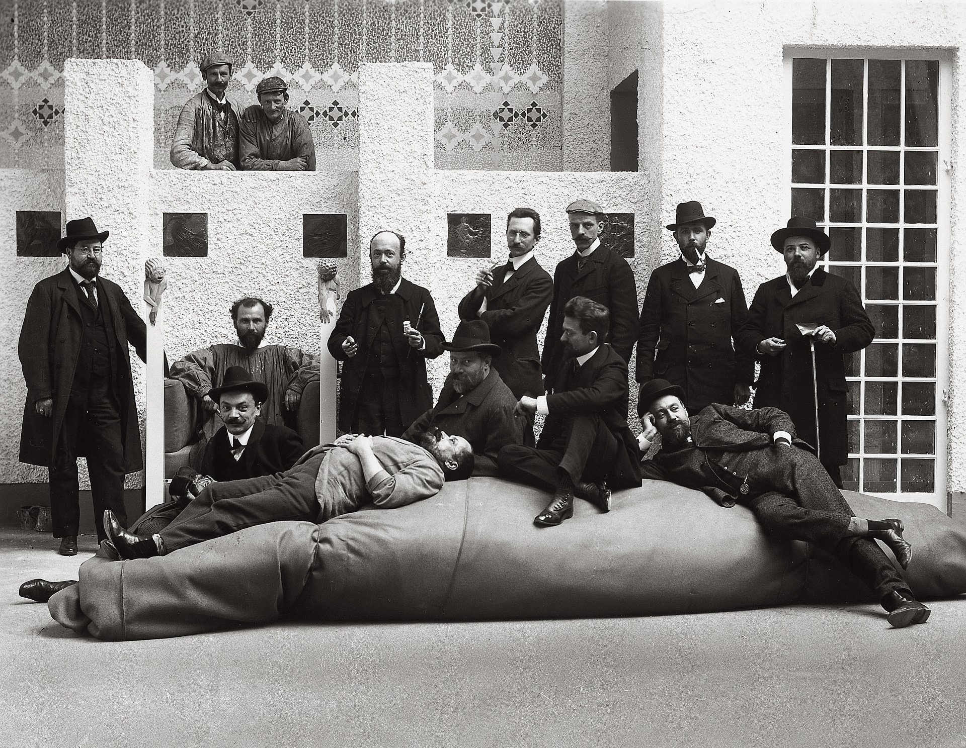 Ritratto di gruppo degli artisti della Secessione viennese; Da sinistra a destra: Anton Nowak, Gustav Klimt (su una sedia realizzata da Ferdinand Andri), Kolo Moser (seduto di fronte a Klimt), Maximilian Lenz (sdraiato). In piedi: Adolf Boehm, Wilhelm List, Maximilian Kurzweil, Leopold Stolba, Rudolf Bacher. Seduti davanti a loro: Ernst Stoehr, Emil Orlik, Carl Moll. Fotografia di Moriz Naehr, 1902, Vienna, Austria